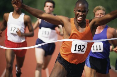 Winner of track and field race crossing finish line