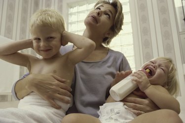 Low angle view of a mother holding her son and daughter