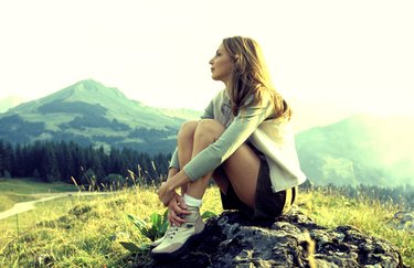 Woman sitting on mountainside