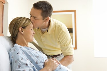 Husband kissing pregnant wife in hospital