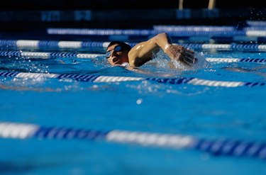 Young person swimming to lose belly fat in pool, surface view