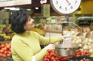 Mid adult woman weighing vegetables in a supermarket