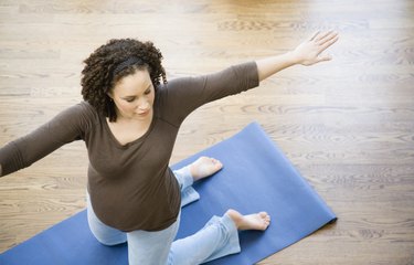 Pregnant African woman practicing yoga