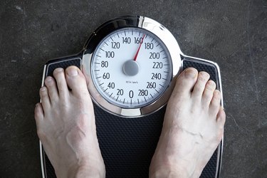 Low section view of a person standing on a weighing scale