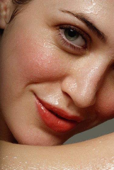 Young woman perspiring, smiling, portrait, close-up