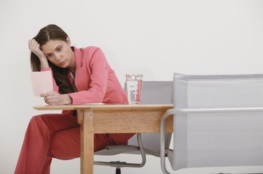 Businesswoman looking at pink slip