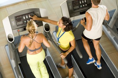 Instructor adjusting treadmill