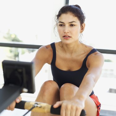 close-up of a young woman exercising on a rowing machine