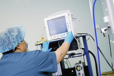 Close-up of a female nurse adjusting a heart monitor