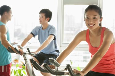 Young people on stationary bikes exercising in the gym