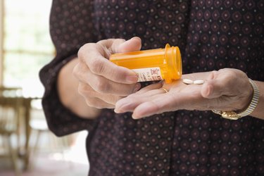 Mixed race woman holding medication pills