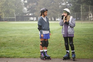 Teenage girls (13-14) wearing in-line skates in park