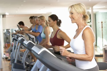 Senior Woman On Running Machine In Gym