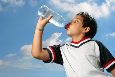 Thirsty boy drinking water outdoors