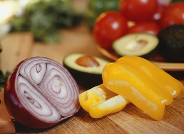 Sliced onion, peppers and avocado on table, close-up