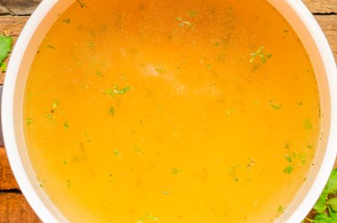 Closeup of broth, clear soup or bouillon  in a saucepan