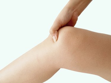 woman holding sore knee, isolated on white background