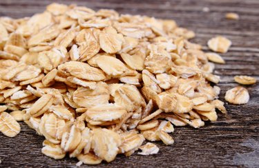 Heap of oat flakes on wooden background