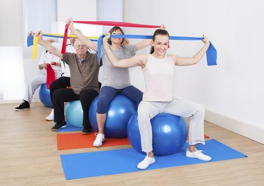People With Resistance Bands Sitting On Fitness Balls