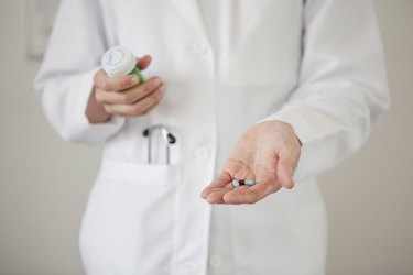 Doctor holding handful of pills