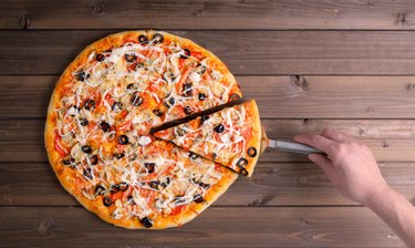 Pizza with cheese and pizza paddle