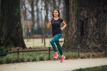 Young girl running outdoors in a city park