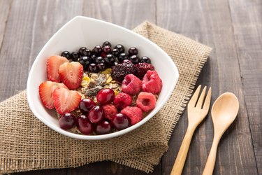 Oatmeal in bowl topped with fresh blueberries, cranberries, stra