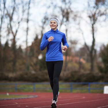 Young woman running at a track and field stadium