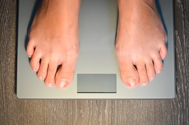 Lose weight concept with person on scale measuring kilograms
