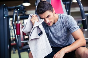 Bodybuilder wipes the sweat at fitness gym