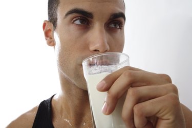 Young man drinking glass of milk, close-up