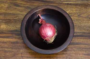 Red onion in wooden bowl