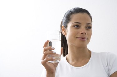 Young woman holding glass of water