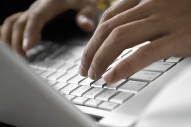 Close-up of a person operating a laptop