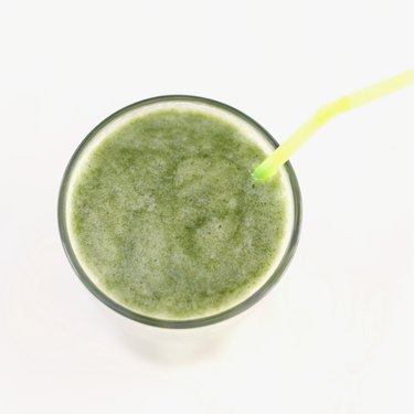 Elevated view of a glass of green juice with a straw