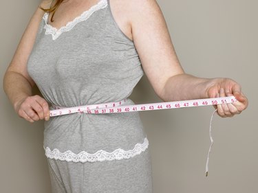 Woman measuring her waist