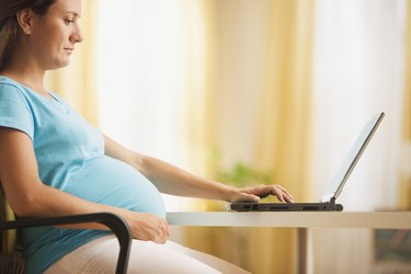 Pregnant woman using a laptop