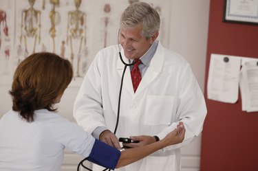 Doctor taking woman's blood pressure