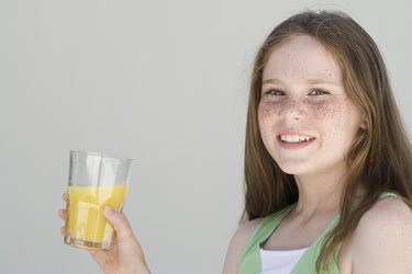 Girl holding glass of orange juice