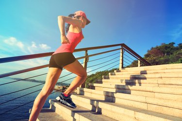 healthy lifestyle sports woman running up on stone stairs seaside
