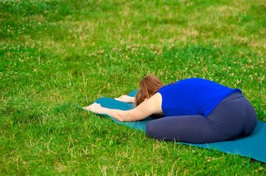 Young woman doing yoga by the lake, located on the docks.  Concept healthy lifestyle. Lots of copy space.