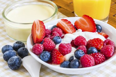 sweet raw berries with orange juice on coverlet