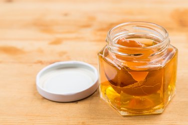 Jar containing soaked egg shell in apple cider vinegar