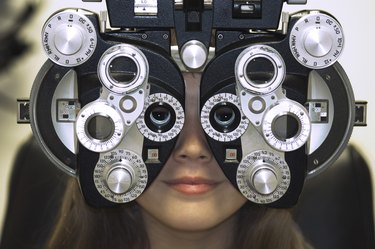 Close-up of a young woman getting an eye test with a phoropter