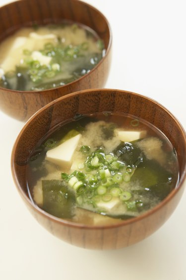 Tofu and seaweed in Miso soup, close up, white background