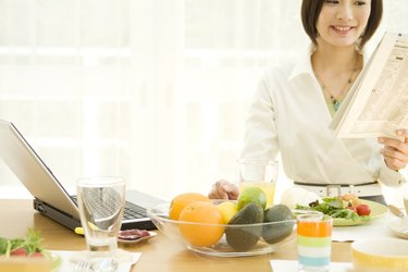 Woman reading the newspaper at breakfast