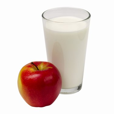 Close up of a glass of milk and an apple