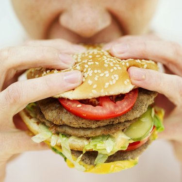 Close-up of a woman eating a hamburger