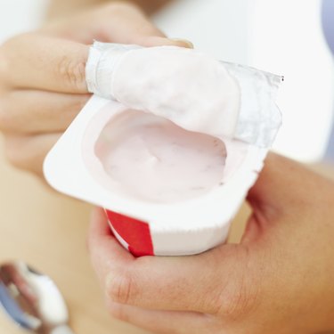 a woman opening strawberry yoghurt