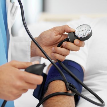 Close-up of doctor taking blood pressure of patient